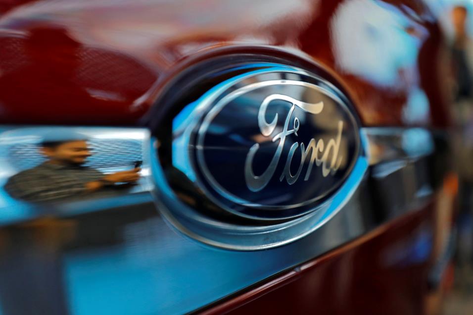 A visitor is reflected as he takes pictures of a new Ford Aspire car during its launch in New Delhi, India, October 4, 2018. REUTERS/Anushree Fadnavis