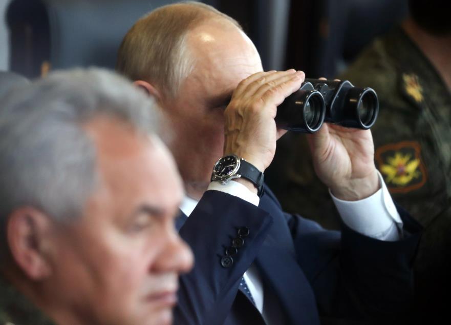 Russian President Vladimir Putin uses a pair of binoculars while observing the military exercises 