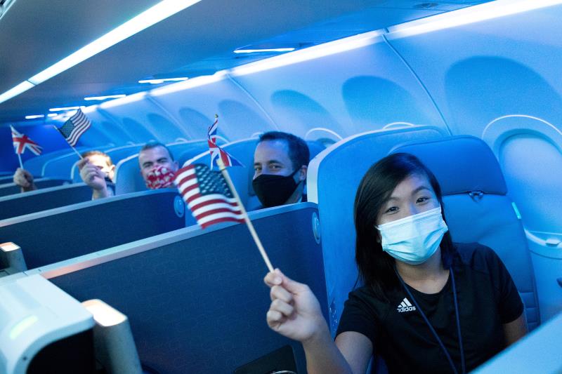 Passengers wearing protective masks hold American and British flags before a JetBlue flight to Lo<em></em>ndon at JFK Internatio<em></em>nal Airport in the Queens borough of New York City, New York, U.S., August 11, 2021. REUTERS/Jeenah Moon