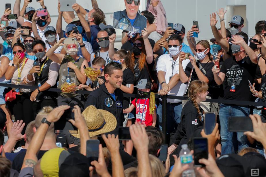 Jared Isaacman, founder and CEO of Shift4 Payments and flight commander, walks with crew member Hayley Arceneaux (R) as the Inspiration 4 crew crew is cheered on by a crowd as they depart for SpaceX Falcon 9 rocket on Pad 39A at the Kennedy Space Center in Cape Canaveral, Florida, U.S., September 15, 2021.  REUTERS/Joe Skipper/File Photo