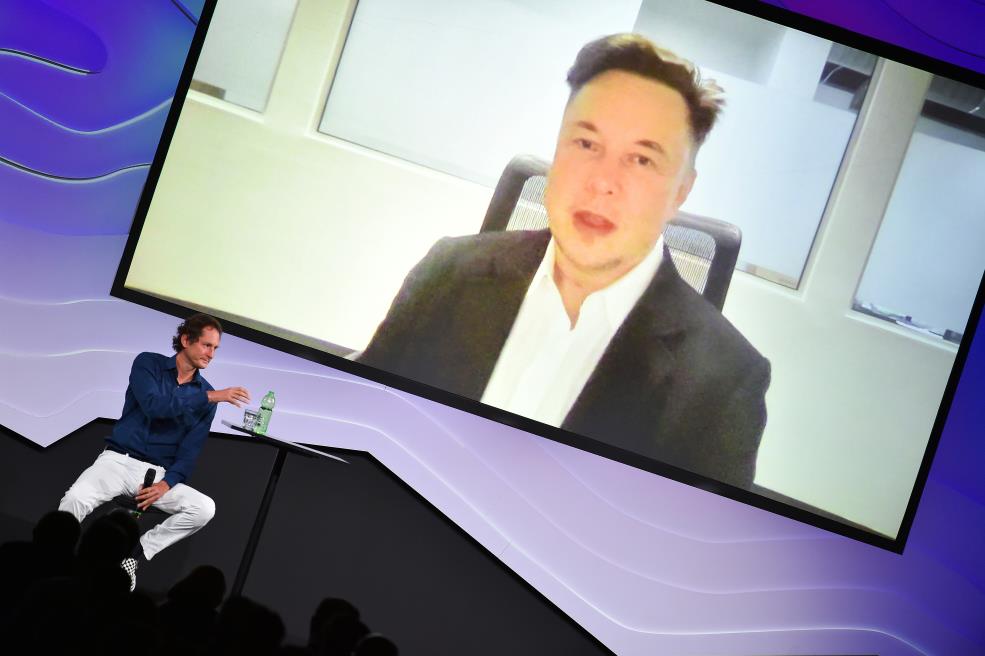 Chairman of Stellantis and Ferrari John Elkann speaks via video co<em></em>nference with Tesla's founder Elon Musk during the 