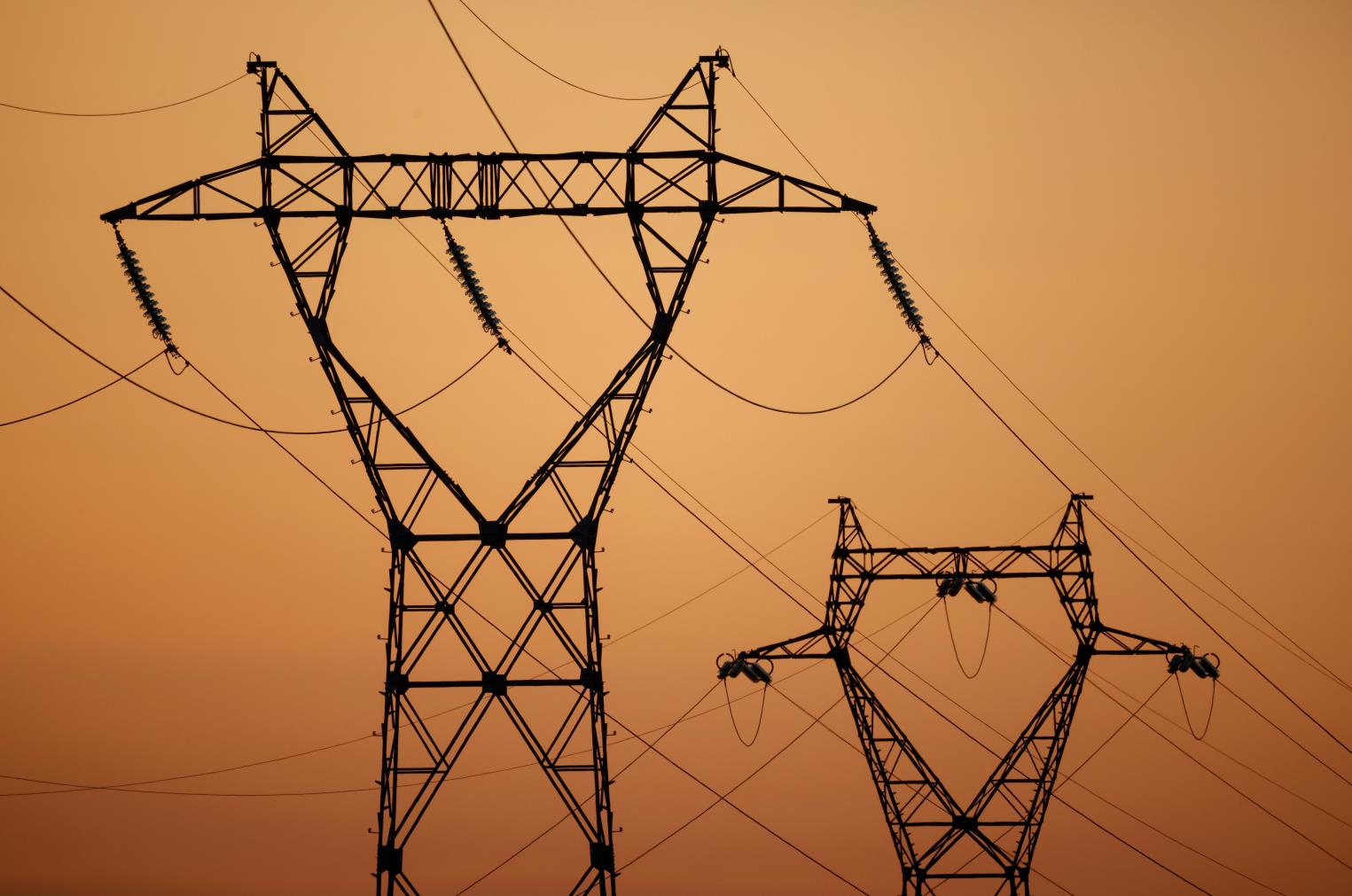 Pylons of high-tension electricity power lines are seen during sunset outside Nantes, France, March 29, 2021. REUTERS/Stephane Mahe