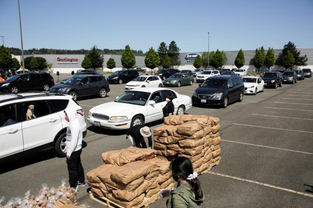 People queue for handouts of excess potatoes, that would otherwise go to waste due to coronavirus-related supply chain blockages, in an event organized by the Washington Potato Commission in Auburn, Washington, U.S. May 7, 2020.  REUTERS/David Ryder