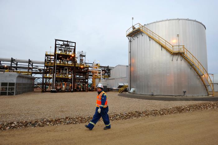 An oilfield worker walks past the Statoil oil sands facility near Conklin, Alberta, November 3, 2011. Statoil plans an expansion of their oil sands operation that will let them produce 60,000 barrels of oil per day by 2016. REUTERS/Todd Korol