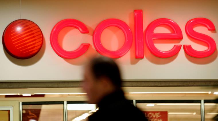 A shopper stands in front of a Coles supermarket sign in a suburban shopping centre in Sydney June 25, 2007.    REUTERS/Mick Tsikas     