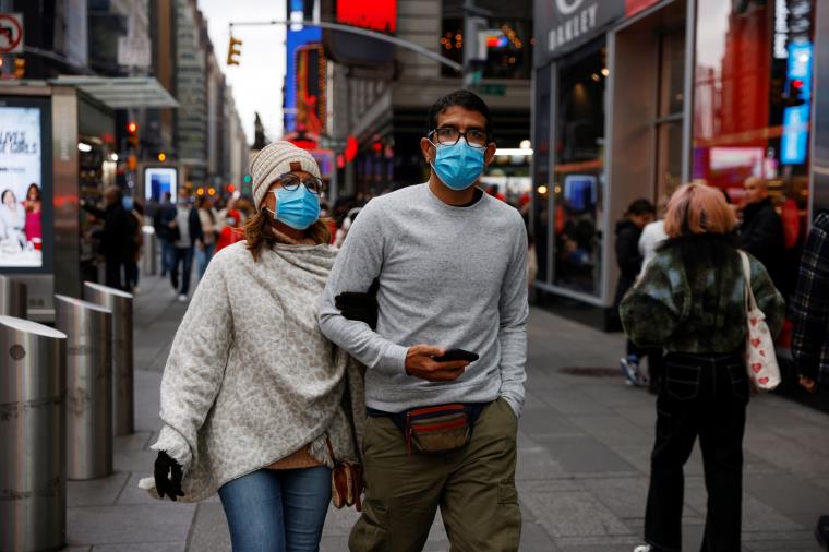 People wearing protective face masks, amid the coro<em></em>navirus disease (COVID-19) pandemic, walk through Times Square in New York City, U.S., November 22, 2021.  REUTERS/Shannon Stapleton