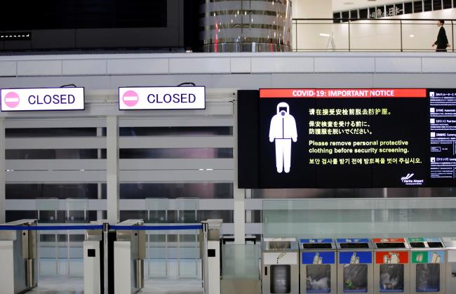 A notice a<em></em>bout COVID-19 safety measures is pictured next to closed doors at a departure hall of Narita internatio<em></em>nal airport on the first day of closed borders to prevent the spread of the new coro<em></em>navirus Omicron variant in Narita, east of Tokyo, Japan, November 30, 2021. REUTERS/Kim Kyung-Hoon