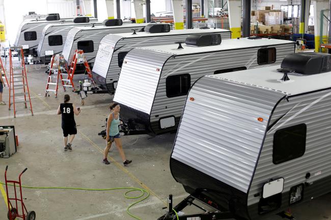 Workers walk around a single axel towable Pio<em></em>neer traditio<em></em>nal recreatio<em></em>nal vehicles at the Thor Industries Heartland RV Assembly Plant in Elkhart, Indiana, U.S. June 13, 2017. REUTERS/Joshua Lott/File Photo