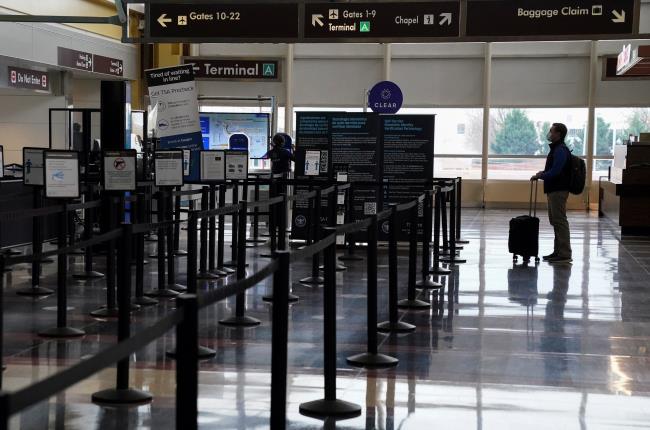 A Christmas week traveler stands by a security gate at Ro<em></em>nald Reagan Washington Natio<em></em>nal Airport, in Arlington, Virginia, U.S., December 22, 2020.  REUTERS/Kevin Lamarque