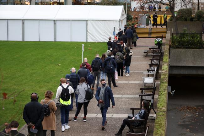 People queue to receive COVID-19 vaccine and booster doses, as the spread of the coro<em></em>navirus disease (COVID-19) continues, at a walk-in vaccination centre at Saint Thomas' Hospital in London, Britain, December 15, 2021. REUTERS/Henry Nicholls