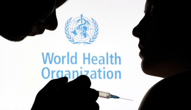 People pose with syringe and needle in front of displayed World Health Organization (WHO) logo, in this illustration taken December 11, 2021. REUTERS/Dado Ruvic/Illustration