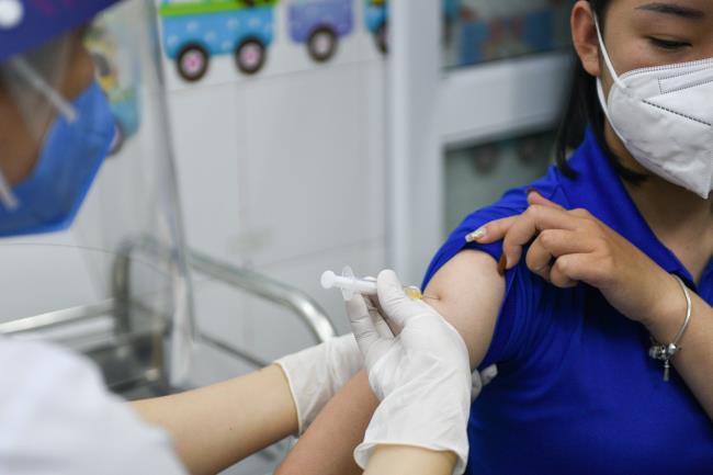 A woman receives a vaccine as Vietnam starts its official rollout of AstraZeneca's coro<em></em>navirus disease (COVID-19) vaccine for health workers, at Hai Duong Hospital for Tropical Diseases, Hai Duong province, Vietnam, March 8, 2021. REUTERS/Thanh Hue