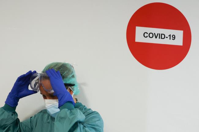 A hospital staff member adjusts protective glasses before treating a patient suffering from the coro<em></em>navirus disease (COVID-19) at Hospital del Mar, wher<em></em>e an additio<em></em>nal ward has been opened to deal with an increase in coro<em></em>navirus patients in Barcelona, Spain July 15, 2021.  REUTERS/Nacho Doce