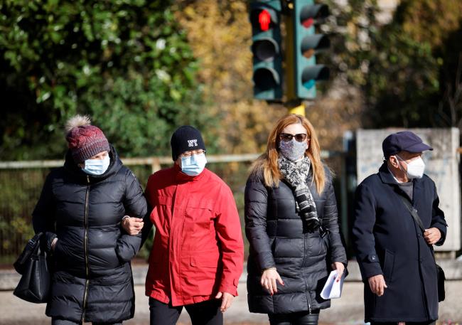 People wearing face masks walk in the street, as the region of Lazio makes face masks mandatory outdoors in all areas, as coro<em></em>navirus disease (COVID-19) cases rise and Christmas nears, in Rome, Italy, December 23, 2021. REUTERS/Yara Nardi