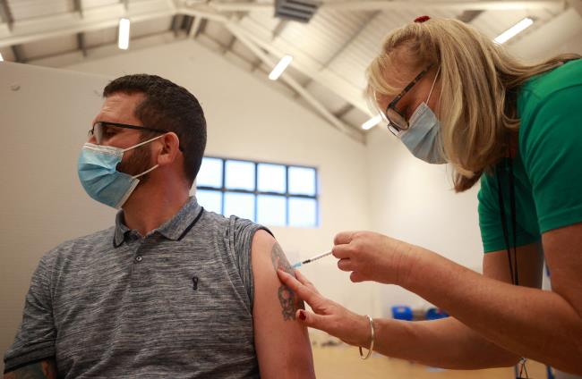 A man receives a coro<em></em>navirus disease (COVID-19) vaccine at the Sovereign Harbour Community Centre on Christmas Day in Eastbourne, Britain, December 25, 2021. REUTERS/Hannah McKay