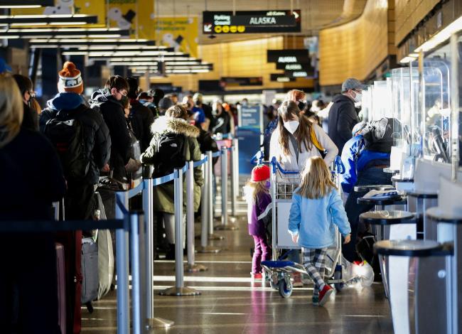 A family works through check-in at Alaska Airlines ticketing after dozens of flights were listed as cancelled or delayed at Seattle-Tacoma Internatio<em></em>nal Airport (Sea-Tac) in Seattle, Washington, U.S. December 27, 2021.  REUTERS/Lindsey Wasson