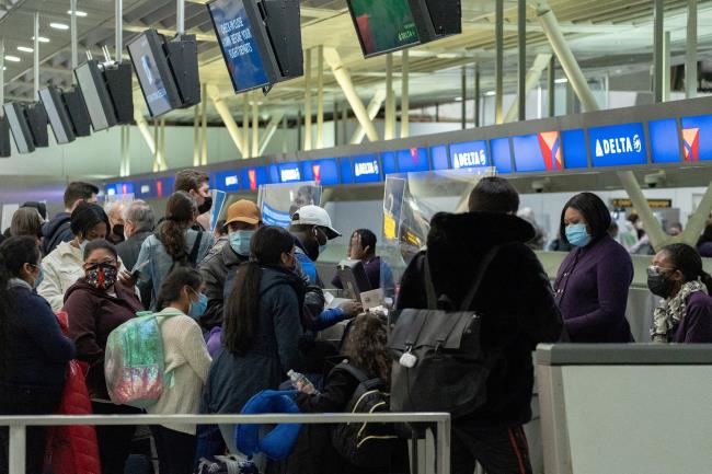 Travelers check in at John F. Kennedy Internatio<em></em>nal Airport during the spread of the Omicron coro<em></em>navirus variant in Queens, New York City, U.S., December 26, 2021. REUTERS/Jeenah Moon/File Photo