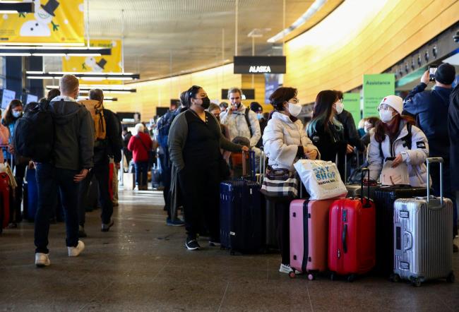 People queue in long ticketing and baggage lines after dozens of flights were listed as cancelled or delayed at Seattle-Tacoma Internatio<em></em>nal Airport (Sea-Tac) in Seattle, Washington, U.S. December 27, 2021.  REUTERS/Lindsey Wasson