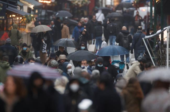 People wearing protective masks are pictured on a rainy winter day in the Mo<em></em>ntorgueil street, amid the spread of the coro<em></em>navirus disease (COVID-19) pandemic, in Paris, France, December 27, 2021. REUTERS/Christian Hartmann