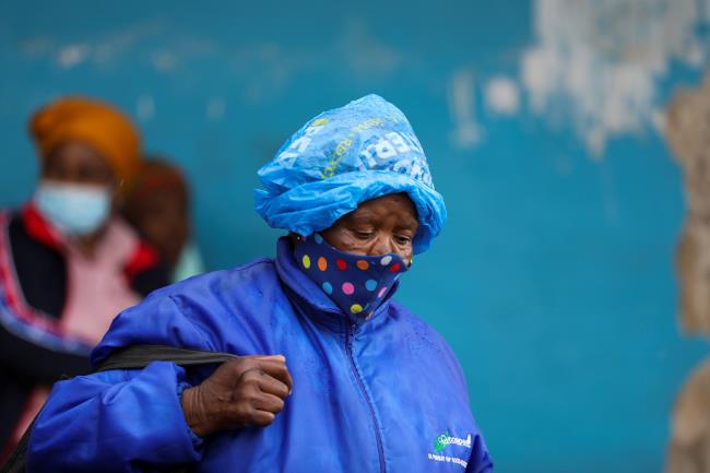 A woman wearing a protective face mask against the coro<em></em>navirus disease (COVID-19) and a plastic bag on her head to protect from the rain looks on, as the new Omicron coro<em></em>navirus variant spreads, at Tsomo, a town in the Eastern Cape province of South Africa, December 2, 2021. Picture taken December 2, 2021. REUTERS/Siphiwe Sibeko