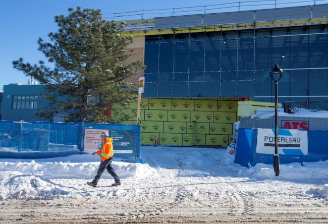 A worker walks past a new extension of the Natio<em></em>nal Research Council of Canada building under construction, in Montreal, Quebec, Canada February 4, 2021.  REUTERS/Christinne Muschi