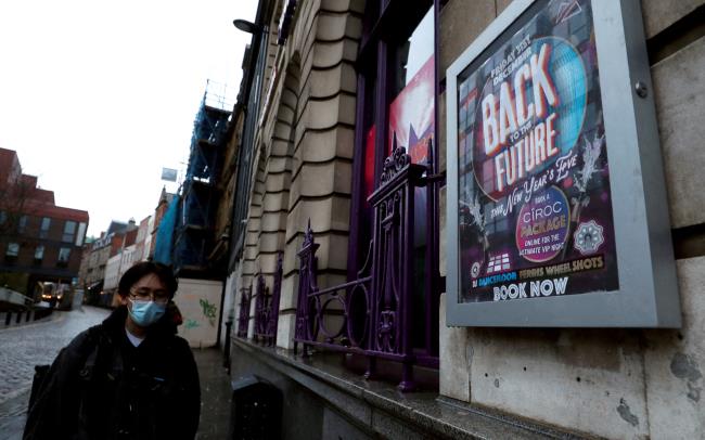 A man in a face mask walks past a New Year's Eve advertisement at Flares Bar, amid the coro<em></em>navirus disease (COVID-19) outbreak, in Newcastle upon Tyne, Britain, December 28, 2021. REUTERS/Lee Smith