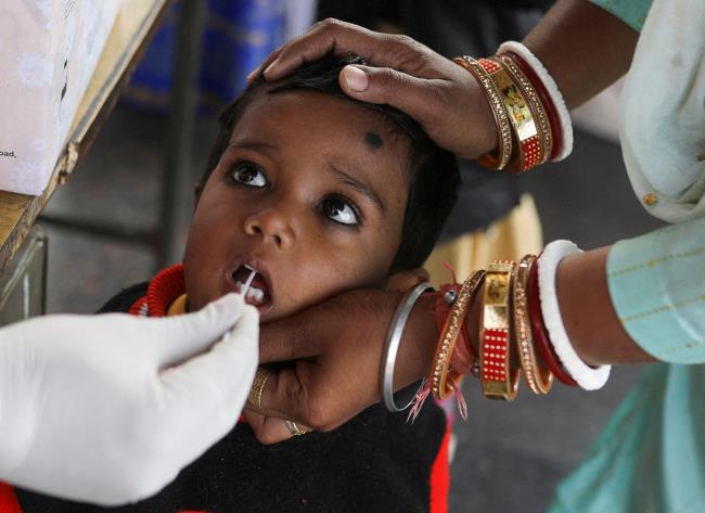 A healthcare worker collects a coro<em></em>navirus disease (COVID-19) test swab sample from a child amidst the spread of the disease, at a railway station in New Delhi, India, December 22, 2021. REUTERS/Anushree Fadnavis 