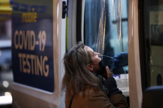 A person takes a COVID-19 test on Broadway as the Omicron coro<em></em>navirus variant co<em></em>ntinues to spread in Manhattan, New York City, U.S., December 27, 2021. REUTERS/Andrew Kelly