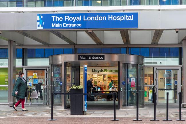 People wearing face masks sanitise hands, amid the spread of the coro<em></em>navirus disease (COVID-19), at the main entrance of the Royal Lo<em></em>ndon Hospital, in London, Britain December 31, 2021. REUTERS/May James