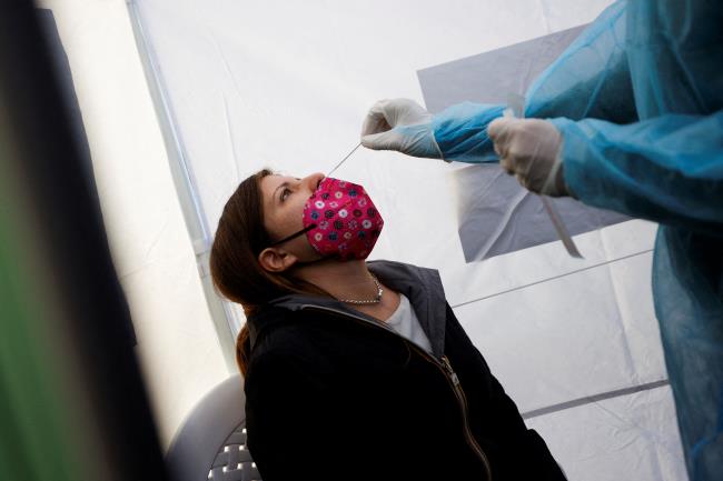 A woman takes a coro<em></em>navirus disease (COVID-19) test at a pharmacy as COVID-19 infections rise in Rome, Italy, December 31, 2021. REUTERS/Guglielmo Mangiapane