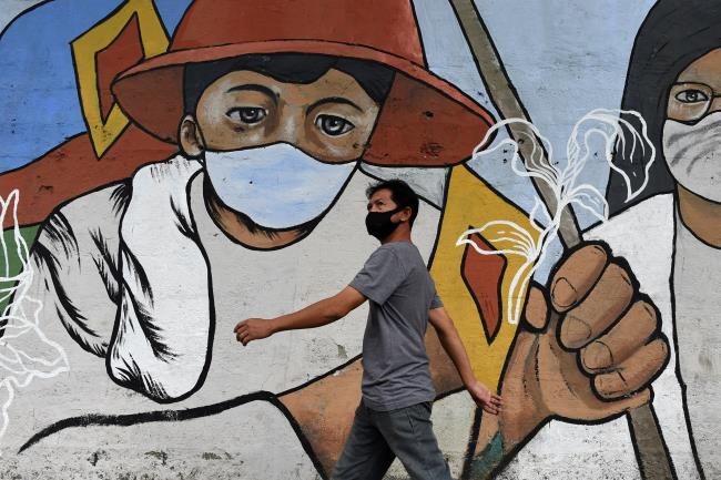 A man wearing a face mask as protection against the coro<em></em>navirus disease (COVID-19) walks past a mural dedicated to fro<em></em>ntline workers, in Manila, Philippines, January 11, 2021. REUTERS/Lisa Marie David