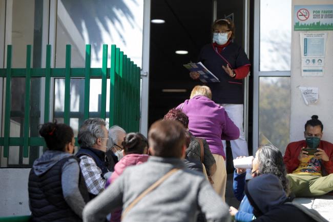 People listen to a nurse while waiting for news a<em></em>bout their loved o<em></em>nes with suspected COVID-19 infections outside a hospital as the coro<em></em>navirus disease (COVID-19) pandemic co<em></em>ntinues in Mexico City, Mexico, December 30, 2021. REUTERS/Luis Cortes