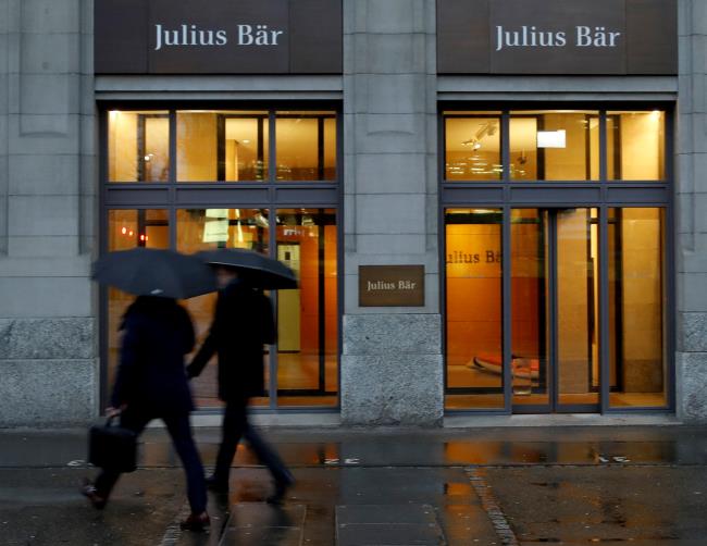 People walk past a branch of Swiss bank Julius Baer in Zurich, Switzerland February 3, 2020. REUTERS/Arnd Wiegmann/File Photo