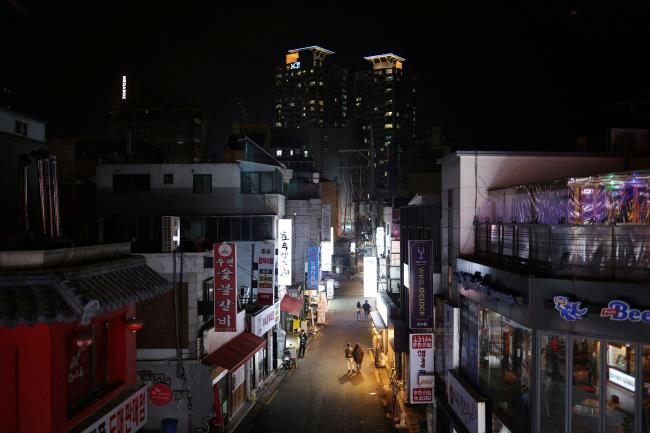 Couples leave a pub during the curfew hours starting at 9:00 p.m., as part of tightened social distancing rules to co<em></em>ntain a surge in coro<em></em>navirus disease (COVID-19) infections, in Seoul, South Korea, December 20, 2021.  REUTERS/Kim Hong-Ji