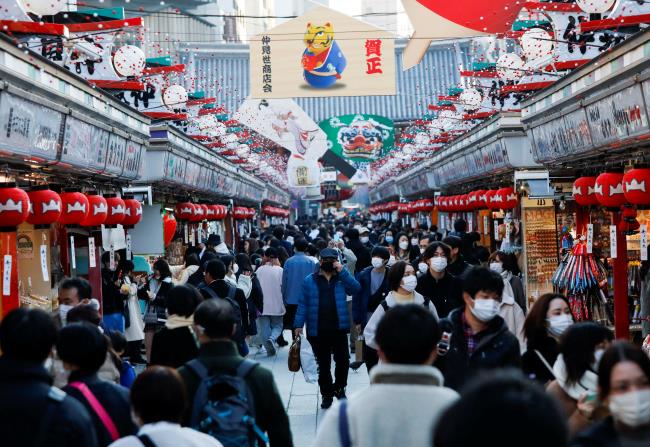 Visitors wearing protective face masks walk under decorations for the New Year at Nakamise street leading to Senso-ji temple at Asakusa district, a popular sightseeing spot, amid the coro<em></em>navirus disease (COVID-19) pandemic, in Tokyo, Japan, December 24, 2021.  REUTERS/Issei Kato