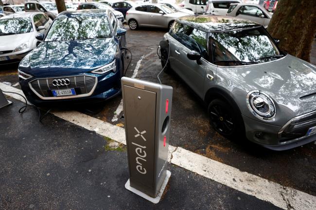 Electric cars are seen plugged in at a charging point for electric vehicles in Rome, Italy, April 28, 2021. REUTERS/Guglielmo Mangiapane