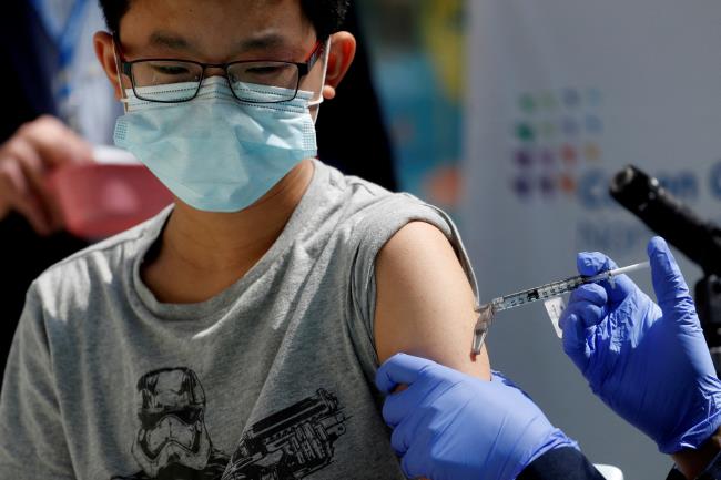 Brendan Lo (13) receives a dose of the Pfizer-Bio<em></em>nTech vaccine for the coro<em></em>navirus disease (COVID-19) at Northwell Health's Cohen Children's Medical Center in New Hyde Park, New York, U.S., May 13, 2021. REUTERS/Shannon Stapleton