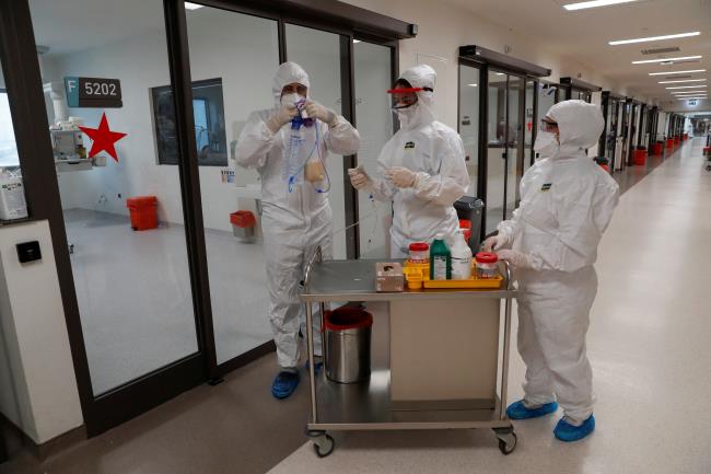 Members of the medical staff Sefa Nacak, Selin Do<em></em>ner and Zeynep Ilk get ready to treat a patient suffering from the coro<em></em>navirus disease (COVID-19) at the intensive care unit (ICU) of the Basaksehir Cam and Sakura City Hospital in Istanbul, Turkey November 25, 2021. REUTERS/Murad Sezer