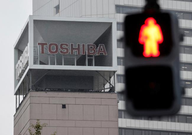 The logo of Toshiba Corp is seen next to a traffic signal in Tokyo, Japan November 9, 2021. REUTERS/Issei Kato/File Photo