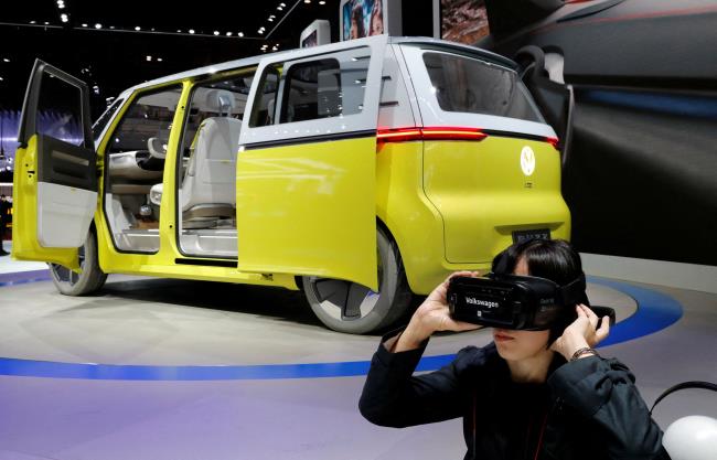 A visitor uses virtual reality device next to Volkswagen's co<em></em>ncept ID.Buzz during media preview of the 45th Tokyo Motor Show in Tokyo, Japan October 25, 2017. REUTERS/Kim Kyung-Hoon