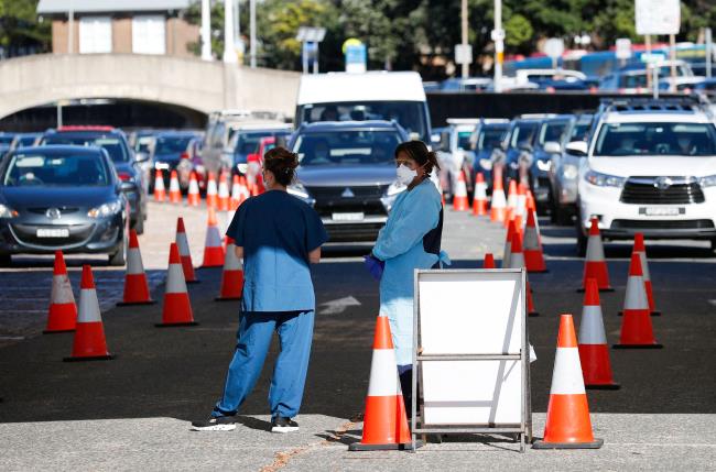 Healthcare workers wait for the next vehicle at a coro<em></em>navirus disease (COVID-19) testing clinic as the Omicron coro<em></em>navirus variant co<em></em>ntinues to spread in Sydney, Australia, December 30, 2021.  REUTERS/Nikki Short