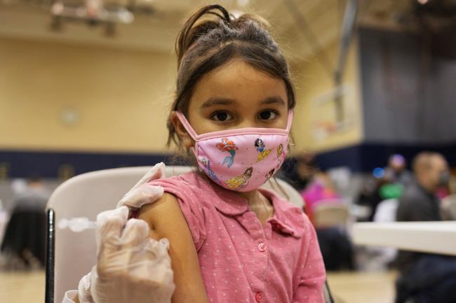 A girl receives the Pfizer-Bio<em></em>nTech coro<em></em>navirus disease (COVID-19) vaccine in Lansdale, Pennsylvania, U.S., December 5, 2021. REUTERS/Hannah Beier