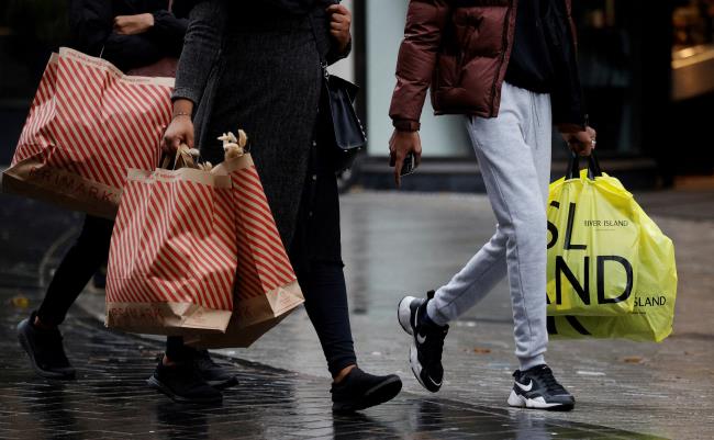 People carry shopping bags as shoppers look for bargains in the traditio<em></em>nal Boxing Day sales in Liverpool, Britain, December 26 , 2021. REUTERS/Phil Noble