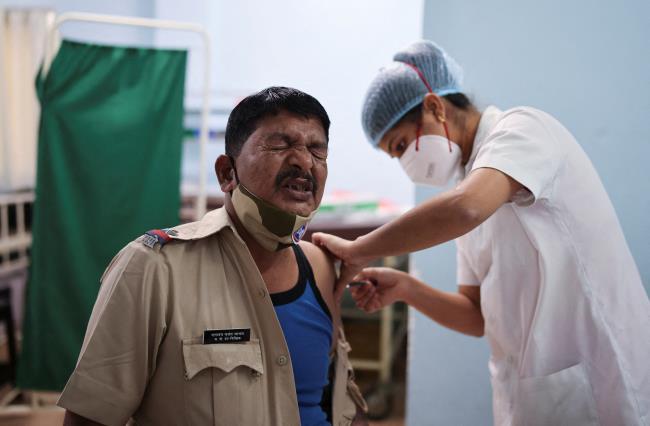 A policeman reacts as he receives a booster dose of the COVISHIELD vaccine against the coro<em></em>navirus disease (COVID-19), manufactured by Serum Institute of India, at a vaccination centre in Mumbai, India, January 10, 2022. REUTERS/Francis Mascarenhas