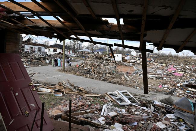 An Amish family gathers on a Christmas Day to speak in a heavily damaged neighborhood, after tornadoes ripped through several U.S. states, in Dawson Springs, Kentucky, U.S., December 25, 2021. REUTERS/Jon Cherry