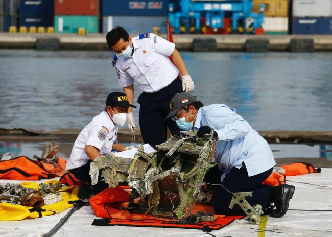 Officers of Indonesia's Natio<em></em>nal Transportation Safety Committee inspect the debris of Sriwijaya Air flight SJ 182, which crashed into the Java Sea, on the last day of its search and rescue operation, at Tanjung Priok port in Jakarta, Indonesia, January 21, 2021. REUTERS/Ajeng Dinar Ulfiana