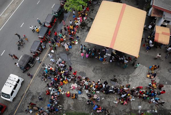 People wait in a queue to buy kerosene at a fuel station, amid the country's eco<em></em>nomic crisis in Colombo