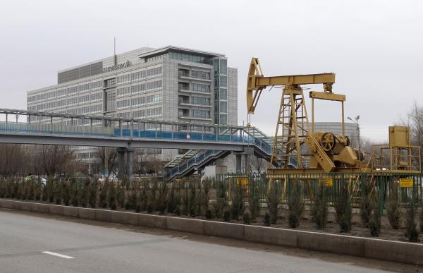 View shows oil well pump jack set as installation in front of Tengizchevroil LLP office in Atyrau