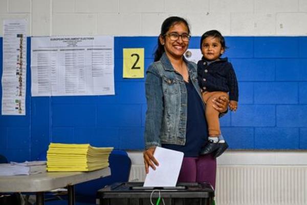 Krish Vadivel helps his mother Ramyaa from Passage West cast her vote.