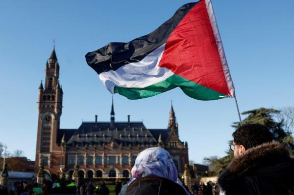 Protesters hold a Palestinian flag as they gather outside the Internatio<em></em>nal Court of Justice (ICJ)